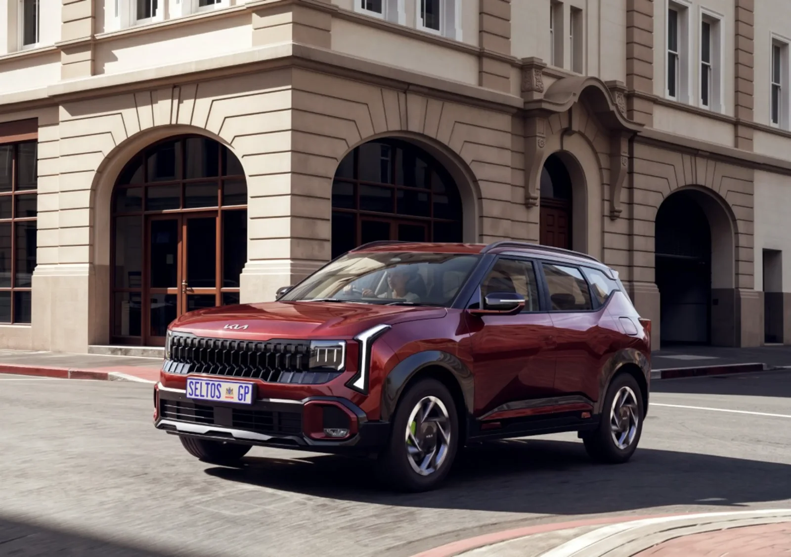 Red all-new Kia Seltos outside a classic city building